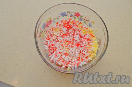 Крабовые палочки разморозить (если они из морозилки), очистить от слюды, мелко нарезать и добавить к размятым желткам.