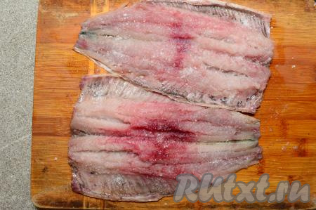 Обе разделанных сельди выложить кожей вниз (как на фото). Посыпать рыбинки 1 чайной ложкой соли. Если у вас будет икра, выложите её поверх филе и тоже посолите.