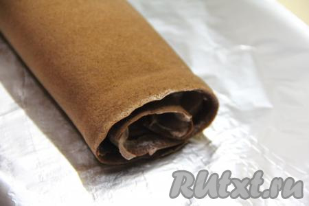 Свернуть бисквит с шоколадным кремом в плотный рулет, начиная с широкой стороны коржа. Завернуть медово-шоколадный рулет в фольгу и поместить в холодильник на ночь, чтобы он как следует пропитался.