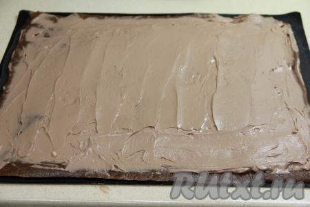 Сливочное масло для приготовления крема должно быть мягким (то есть согревшимся при комнатной температуре), поэтому его нужно предварительно достать из холодильника. Для получения крема нужно соединить мягкое сливочное масло и шоколадную пасту, взбить миксером до однородного состояния. Ещё горячий корж свернуть в рулет вместе с ковриком (или пергаментом) и оставить на 10 минут. Развернуть корж, аккуратно удалить коврик (или пергамент). Смазать корж сверху кремом, немного отступив от краёв.