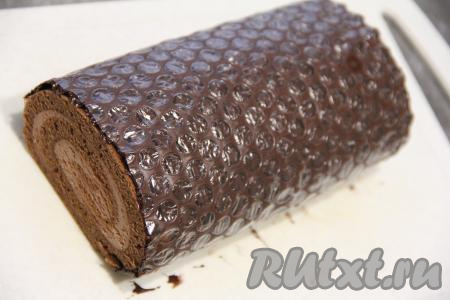 Сразу накрыть рулет шоколадом (плёнка будет наружу) и поставить его в холодильник на 10-15 минут.