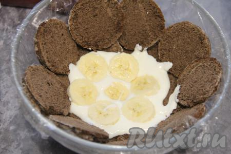 Бананы очистить и нарезать на кружочки. Выложить часть кружочков банана на крем.