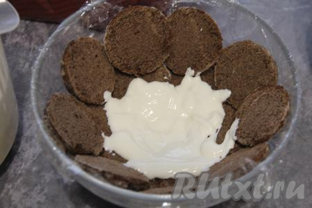 Выложить на дно поверх пряников немного сметанного крема.