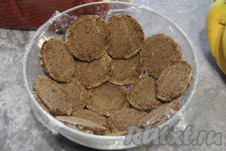 Миску в виде полусферы (я взяла миску диаметром 22 сантиметра) выстелить пищевой плёнкой так, чтобы края плёнки свисали с краёв миски. Выложить ("застелить") миску дольками верхушек пряников. Верхушки должны "смотреть" на плёнку - это будет панцирь.