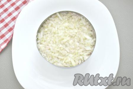 Нарезаем мелко очищенный лук, на пару минут заливаем его 100 миллилитрами кипятка, чтобы он не горчил, затем отжимаем от лишней жидкости. Выкладываем подготовленный лук поверх консервов.
