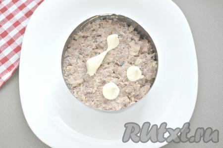 Рыбные консервы без масла перекладываем на тарелку, разминаем вилкой. Равномерно выкладываем консервы следующим слоем салата и покрываем майонезом.