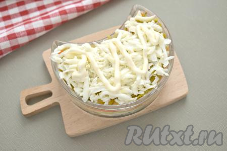 Разделяем варёные яйца на белки и желтки. Поверх огурцов выкладываем белки, натёртые на крупной тёрке, смазываем сверху майонезом.