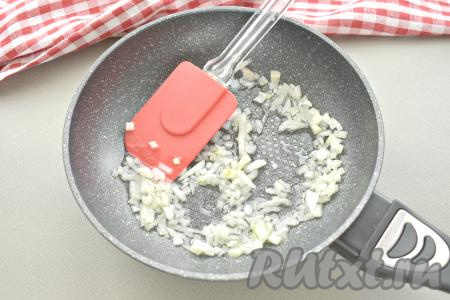 Пока варятся макароны, очищаем репчатый лук, нарезаем его мелко и отправляем на сковороду с разогретым растительным маслом. Обжариваем лук, периодически перемешивая, 2-3 минуты на среднем огне.