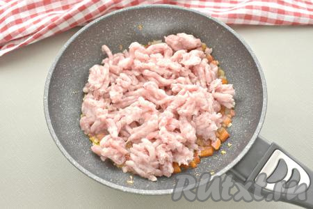 Добавляем в сковороду мясной фарш, перемешиваем. Обжариваем фарш с луком и болгарским перцем 10-12 минут, периодически перемешивая и разбивая комочки фарша лопаточкой.