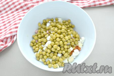 Зелёный консервированный горошек из банки выкладываем сначала на дуршлаг или сито. Когда жидкость с горошка уйдёт, добавляем его в миску.