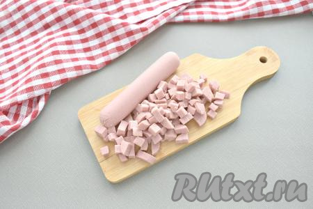 Сосиски используем качественные, с любимым вкусом. Нарезаем сосиски, очищенные от слюды, на кубики примерно такого же размера, как нарезали картошку и морковь.