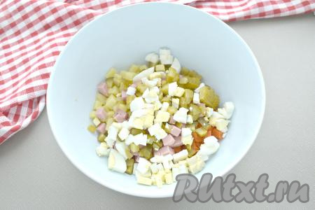 Яйца тоже нарезаем на небольшие кубики и сразу же добавляем в миску с сосисками и овощами.