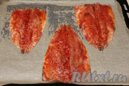 Противень застелить пергаментом. Скумбрию, замаринованную в смеси масла, паприки и чеснока, выложить на противень кожицей вниз. Поставить противень с рыбой в разогретую духовку.