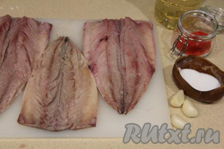 Скумбрию разморозить при комнатной температуре. Отрезать у рыбы плавники, голову, хвост. Разрезать вдоль брюшка, удалить внутренности, основную хребтовую кость, а также более мелкие косточки, промыть. Обсушить филе скумбрии бумажным полотенцем. Чеснок почистить.