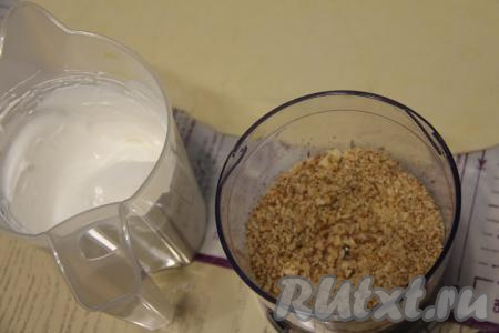 Для приготовления начинки прежде всего нужно охлаждённые яичные белки взбить миксером, постепенно добавляя сахар. Взбивать нужно до стойких пиков и полного растворения сахара. Орехи измельчить в крошку.