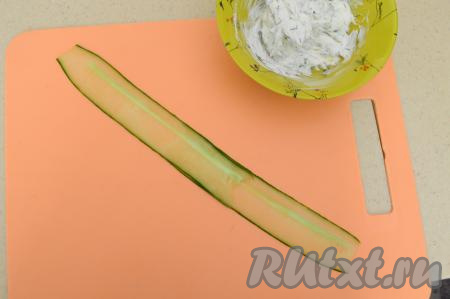 На разделочную доску выложить внахлёст две полоски огурца.