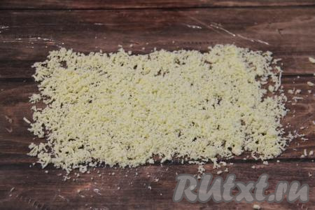 Пищевую плёнку расстелить на кухонном столе. Отделить желтки от белков. Раскрошить желтки и выложить на пищевую плёнку в виде прямоугольника.