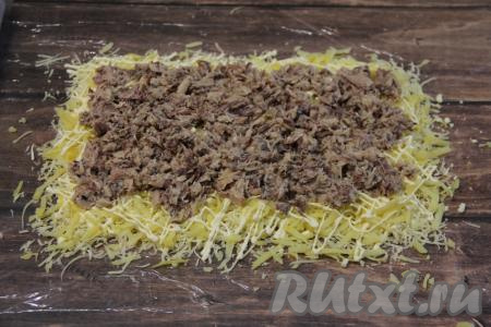 Рыбные консервы открыть, слить лишнее масло (оно нам не понадобится) и размять содержимое банки вилкой. Выложить слой рыбных консервов на картофельный слой.