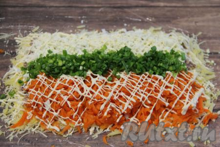 Нанести на морковь и белки сеточку из майонеза. Зелёный лук промыть, мелко нарезать, а затем выложить в виде полоски между белками и морковкой.