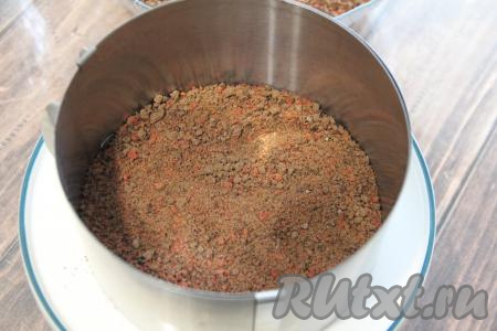 Бортики разъёмной формы (у меня форма диаметром 18 сантиметров) поставить на тарелку или подставку. Разделить пряничную крошку на 4 равные части (слои в торте будут повторяться 4 раза). Выложить одну часть крошки и слегка утрамбовать.