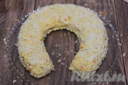 Поверх морковки выложить натёртые на крупной тёрке яйца. Утрамбовать слои и выровнять форму подковы.
