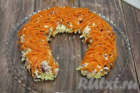 Поверх лука равномерно разложить корейскую морковь, слегка смазать майонезом.