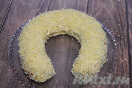 Затем нанести сеточку из майонеза и покрыть салат "Подкова" сверху и по бокам натёртым на мелкой тёрке сыром. 