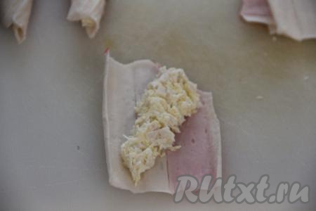 Выложить часть крабово-сырной начинки в виде треугольника на квадрат, располагая начинку по диагонали, начиная от отрезанного уголка.