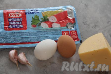 Прежде всего отварить яйца в течение 10 минут с момента закипания воды, затем залить из холодной водой и оставить остывать. Крабовые палочки разморозить при комнатной температуре, затем снять с них слюду.