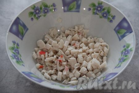 Оставшиеся части крабовых палочек (без красной полосы) мелко нарезать, выложить в глубокую тарелку.