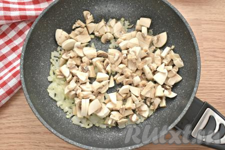 Ополаскиваем шампиньоны водой, нарезаем на небольшие кусочки и выкладываем на сковороду с луком, обжариваем до полного испарения влаги (минут 7-8), периодически помешивая. Обжаренные грибы с луком остужаем.