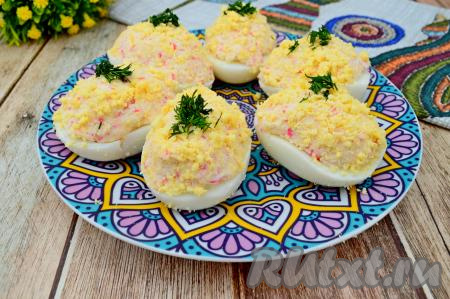 Яйца, фаршированные нежной начинкой из сыра и крабовых палочек, выкладываем на блюдо, по желанию, украшаем мелко нарезанным укропом. Эта вкусная, аппетитная закуска станет украшением и повседневного, и праздничного стола.