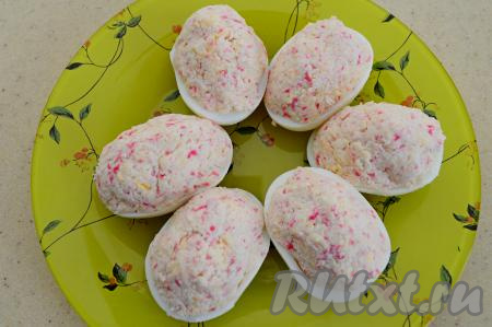 Наполнить крабово-сырной массой половинки яичных белков. Начинки не жалеем, распределяем её горочкой сверху.