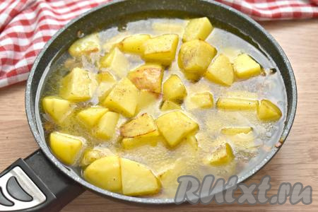 Содержимое сковороды заливаем тёплой кипячёной водой так, чтобы она покрыла картошку не полностью (выше середины).