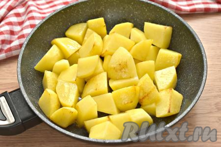 На сковороде с высокими бортиками разогреваем 2 столовых ложки растительного масла, затем выкладываем картошку (желательно в один слой) и обжариваем со всех сторон на достаточно сильном огне 5-7 минут.&nbsp; Кусочки картофеля покроются лёгкой корочкой, но внутри будут сырыми. Обжаренный картофель со сковороды перекладываем на тарелку. Такой "подготовительный" кулинарный приём позволит не развалиться картошке при тушении, готовое блюдо не будет похоже на кашу.
