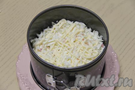 Завершающим слоем салата с крабовыми палочками и ветчиной выложить натёртые на крупной тёрке белки, нанести на них сеточку из майонеза. Аккуратно утрамбовать салат и поставить в холодильник на пару часов пропитаться.