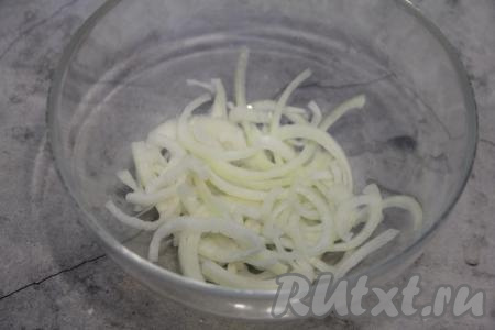 Лук почистить и нарезать тонкими полукольцами. В достаточно объёмную миску выложить половину нарезанного лука.