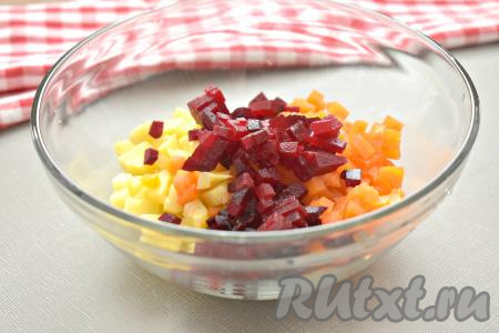 Варёную свеклу тоже нарезаем на маленькие кубики, перекладываем в миску с морковью и картофелем. Стараемся нарезать отваренные овощи одинаково, чтобы готовый винегрет выглядел красиво и аппетитно.