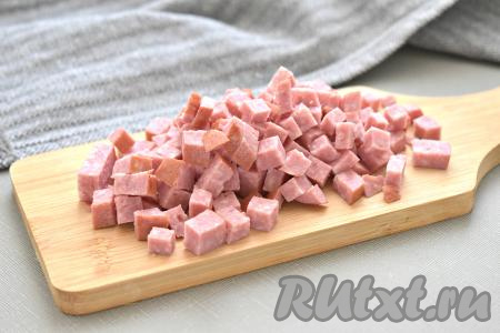 Удаляем с копчёной колбасы шкурку. Нарезаем колбаску на небольшие кубики.