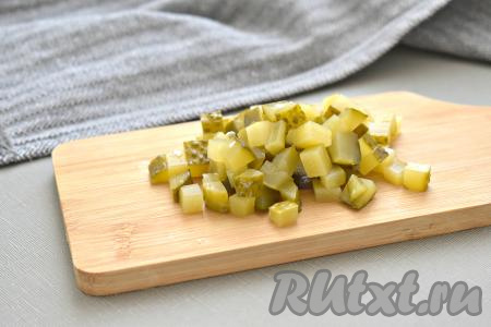 На небольшие кубики нарезаем маринованный огурчик.
