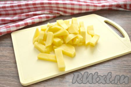 В кастрюлю, в которой будете варить щи, вливаем 1,7-2 литра воды и ставим на огонь. Нарезаем очищенный картофель на брусочки. В закипевшую воду выкладываем картофель и варим с момента закипания на умеренном огне 3-5 минут.