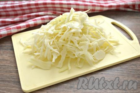 Затем в кастрюлю выкладываем капусту, нарезанную на тонкие полоски, снова даём воде закипеть и варим на небольшом огне 15-20 минут.