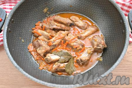 Тушим свиные рёбра с луком и морковью минут 30, накрыв сковороду крышкой.