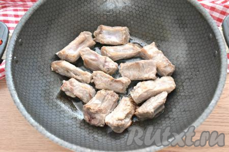 Наливаем на сковороду масло, разогреваем его. Огонь делаем достаточно сильным, выкладываем на сковороду рёбрышки. Обжариваем их, периодически перемешивая, 10 минут. Рёбрышки должны покрыться румяной корочкой со всех сторон.