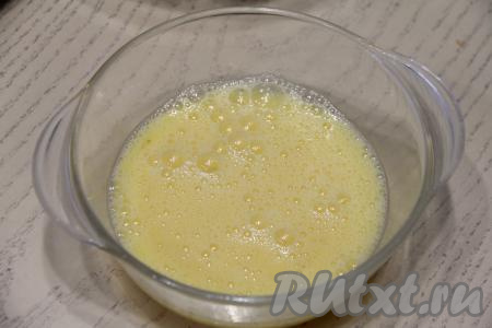 Для приготовления блинчиков соединить в отдельной ёмкости сырые яйца, молоко и щепотку соли. Взбить яичную массу венчиком (или вилкой) до однородности.