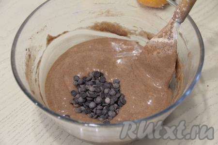 Ещё раз перемешать тесто лопаткой до однородного и гладкого состояния. Затем влить растительное масло и вмешать его в тесто. Я дополнительно добавила капли шоколада, можно их заменить на колотый шоколад или вообще не добавлять, перемешать. Тесто получится воздушным, напоминающим сметану средней густоты.