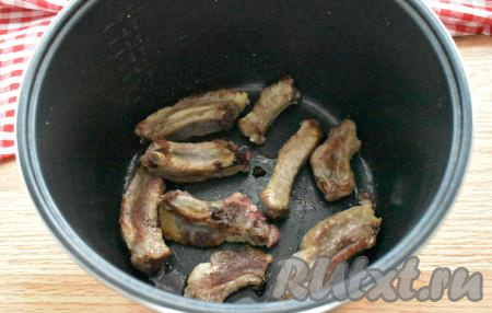 В чашу мультиварки (у меня - мультиварка Редмонд) вливаем 2 столовых ложки растительного масла. Включаем режим "Жарка" на 30 минут. Когда масло разогреется (прозвучит звуковой сигнал), в чашу выкладываем рёбрышки и обжариваем их 15 минут, иногда перемешивая.