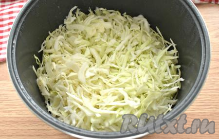 Через полчаса крышку открываем, в чашу к рёбрышкам добавляем тонко нарезанную капусту, перемешиваем, крышку закрываем.