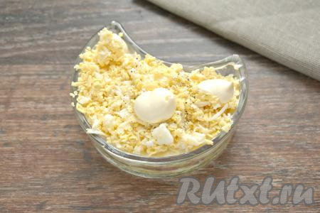 Следующим слоем будут натёртые на крупной тёрке яйца, немного перчим и солим их, наносим майонез.