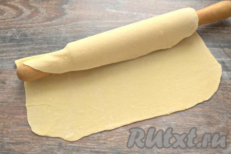 По истечении времени делим тесто на 2-3 куска. Вначале один кусок теста раскатываем на присыпанной мукой поверхности в очень тонкий пласт (толщиной примерно 1-2 миллиметра).